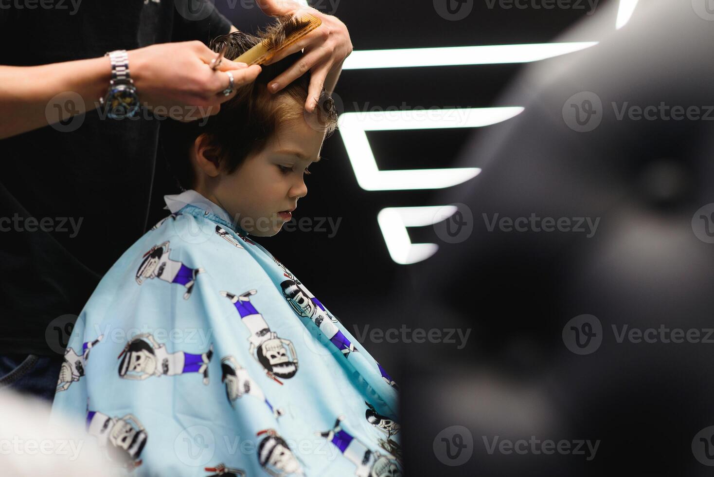 alegre caucásico chico consiguiendo peinado en barbería foto