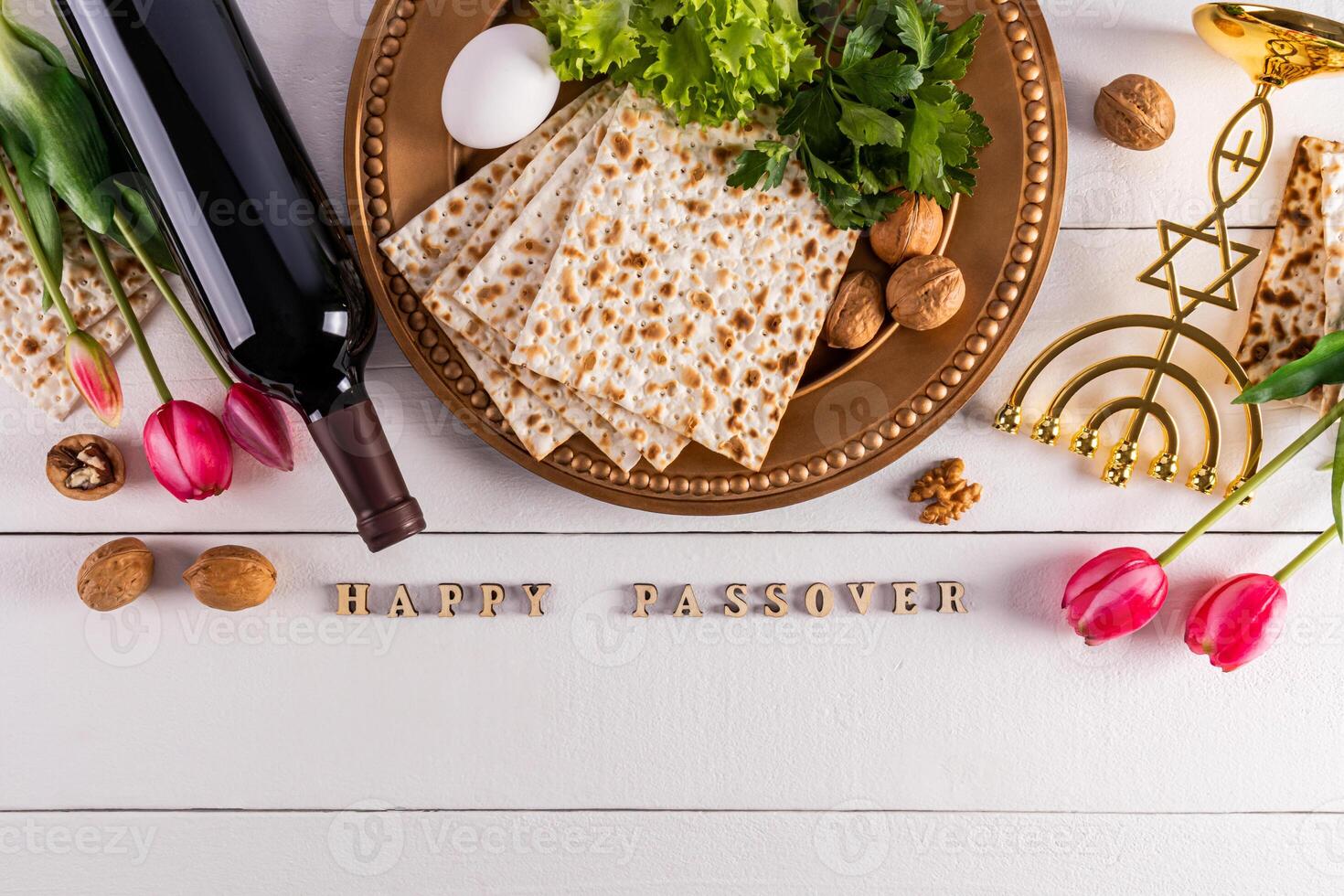Festive background for the spring holiday of the Jewish Passover. Traditional foods, flowers, minor candlestick. Text of Happy Passover photo