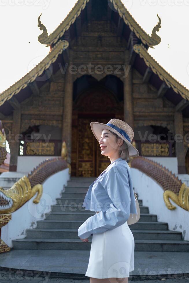 Traveler Asian woman traveling and walking in Bangkok Chiang Mai Temple, Thailand, backpacker female feeling happy spending relax time in holiday trip photo