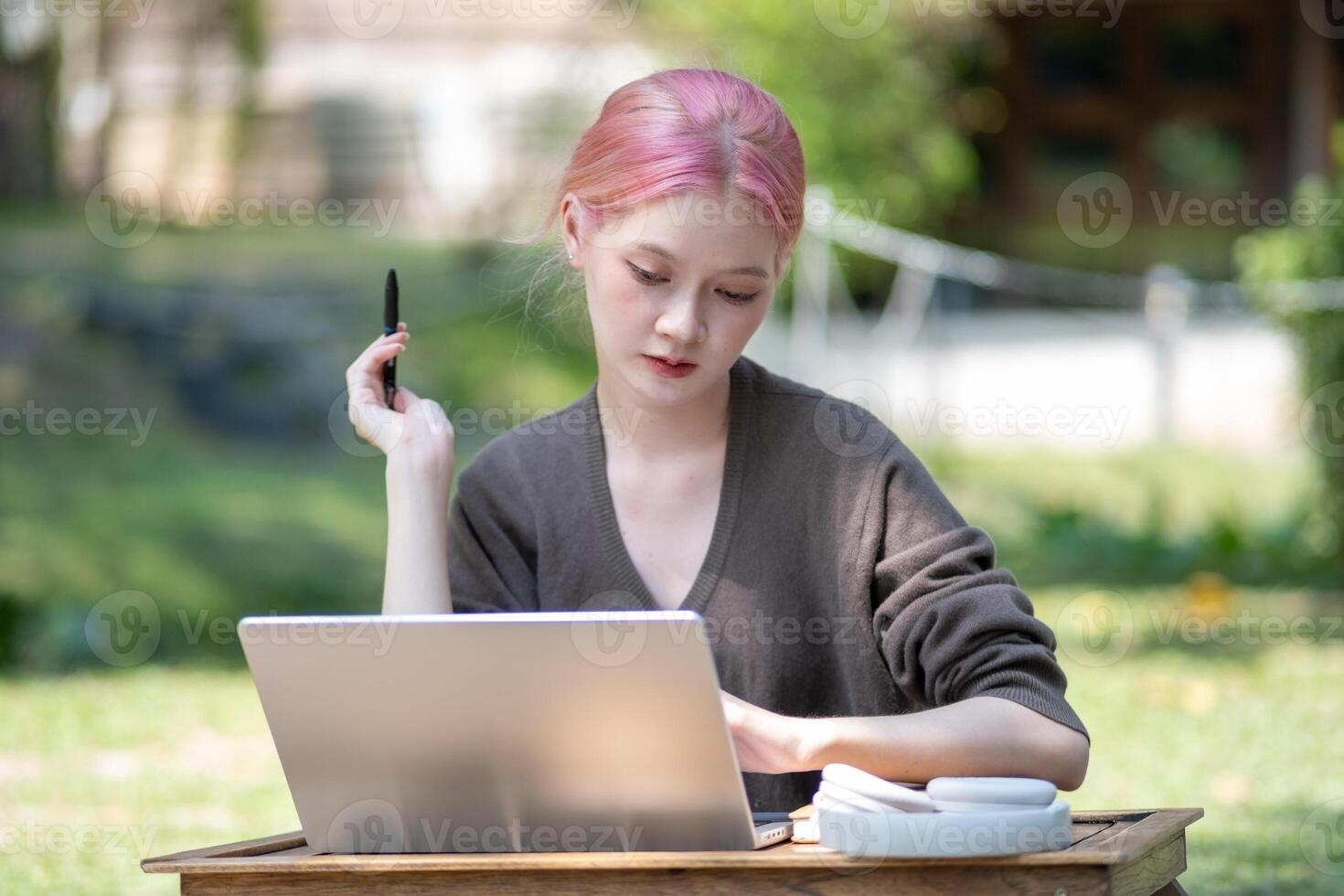 Woman working at the laptop in the backyard with a lot of greenery,  laptop and portrait of woman in park for education photo