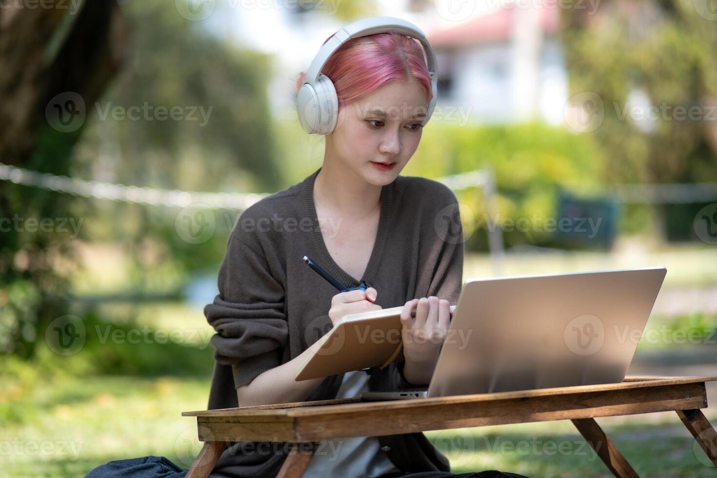 Woman working at the laptop in the backyard with a lot of greenery,  laptop and portrait of woman in park for education photo