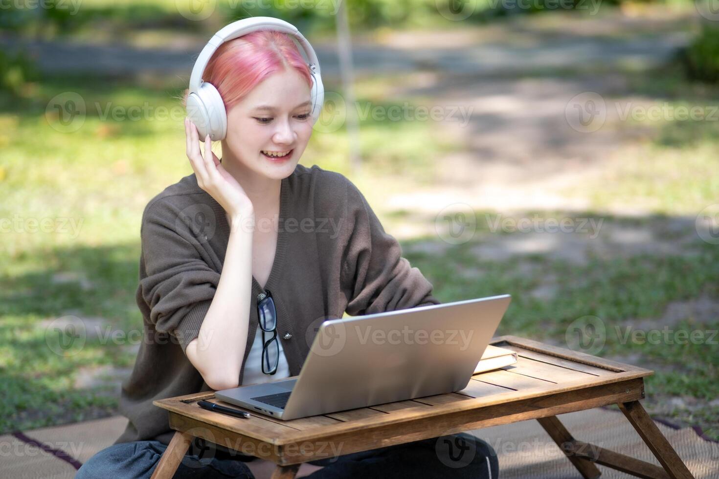 Woman working at the laptop in the backyard with a lot of greenery,  laptop and portrait of woman in park for education photo