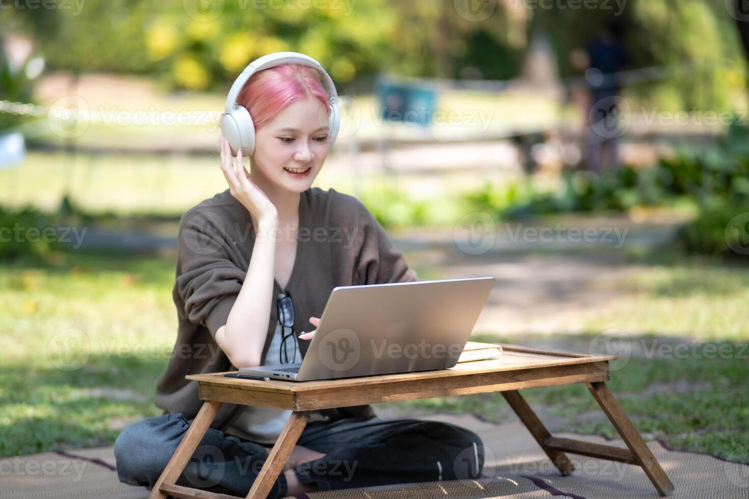 Woman working at the laptop in the backyard with a lot of greenery,  laptop and portrait of woman in park for education photo