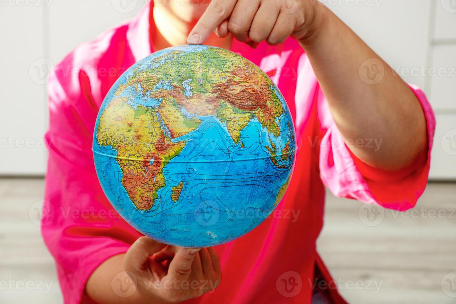 woman holding a physical globe in her hands photo