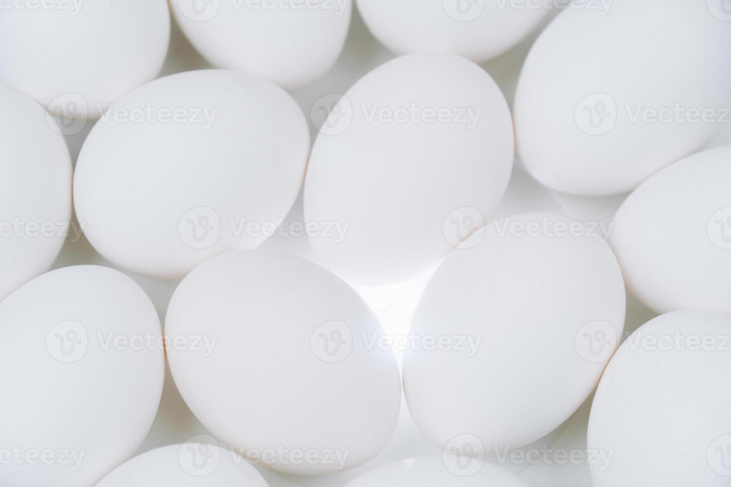 Close up of many white eggs background. Raw eggs on a white backlit platform photo