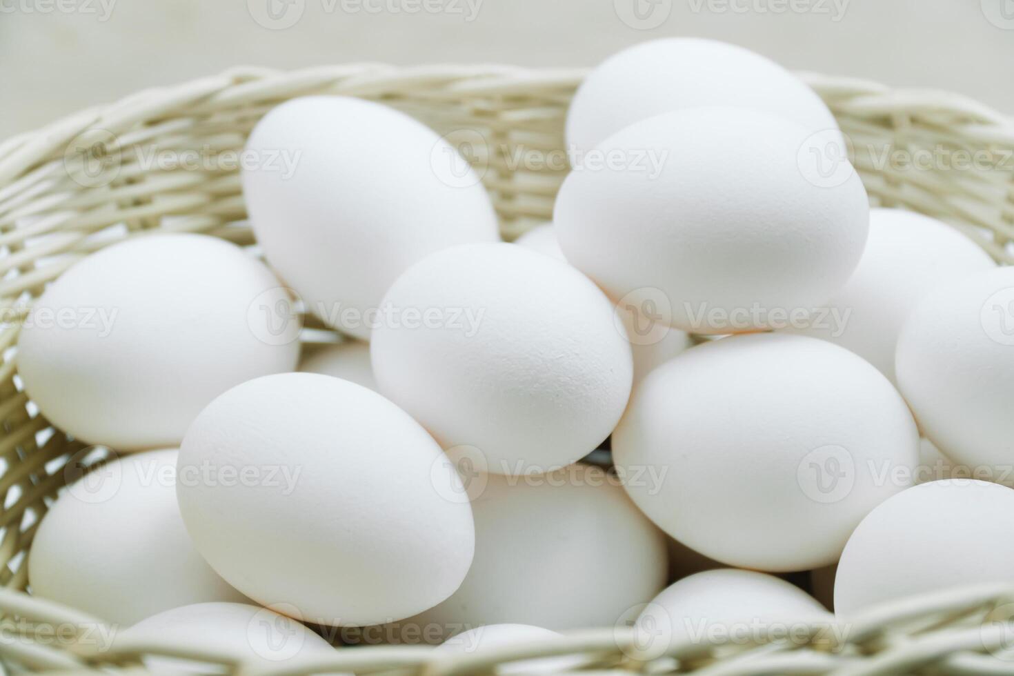 Raw white chicken eggs in a basket top view photo