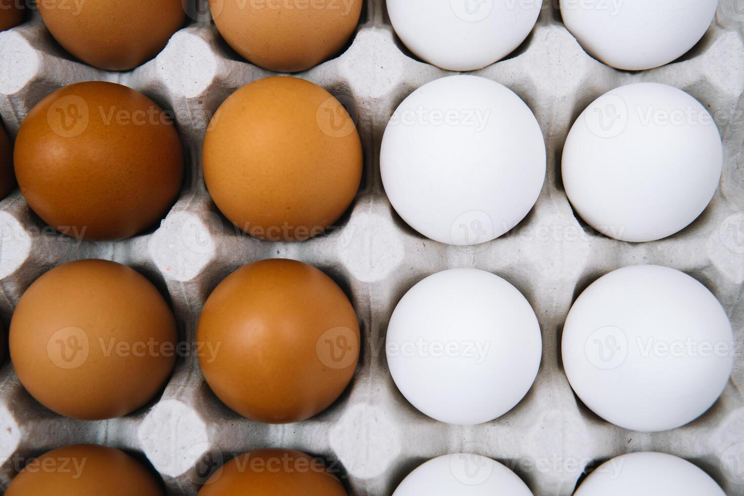 Flat lay of white and brown eggs in egg paper box. Fresh chicken eggs background. Top view natural organic egg. Healthy real food photo