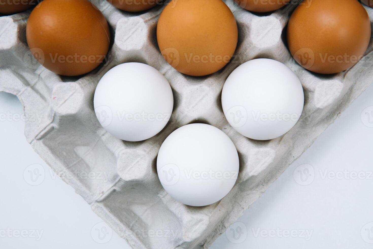 Flat lay of white and brown eggs in egg paper box. Fresh chicken eggs background. Top view natural organic egg. Healthy real food photo