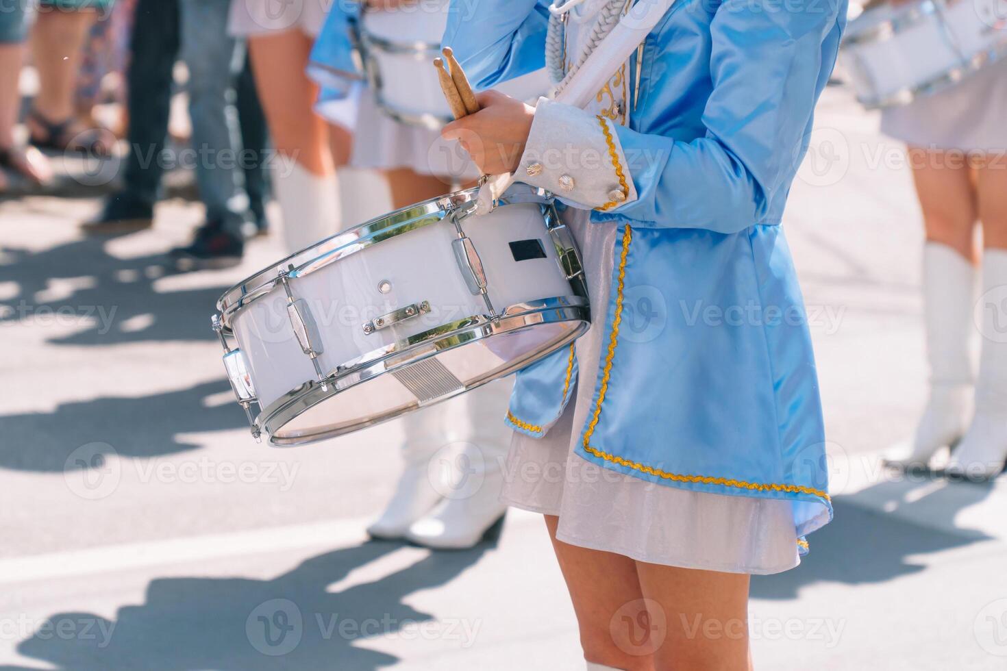 Majorettes and marching band. Young girls drummer at the parade. Street performance photo