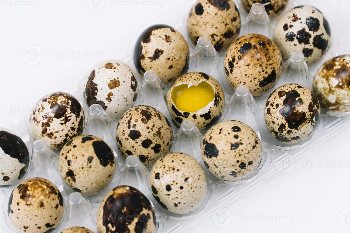 Fresh raw quail eggs and alone broken egg. Flat lay of raw quail eggs in box. Top view natural organic egg. Healthy real food photo