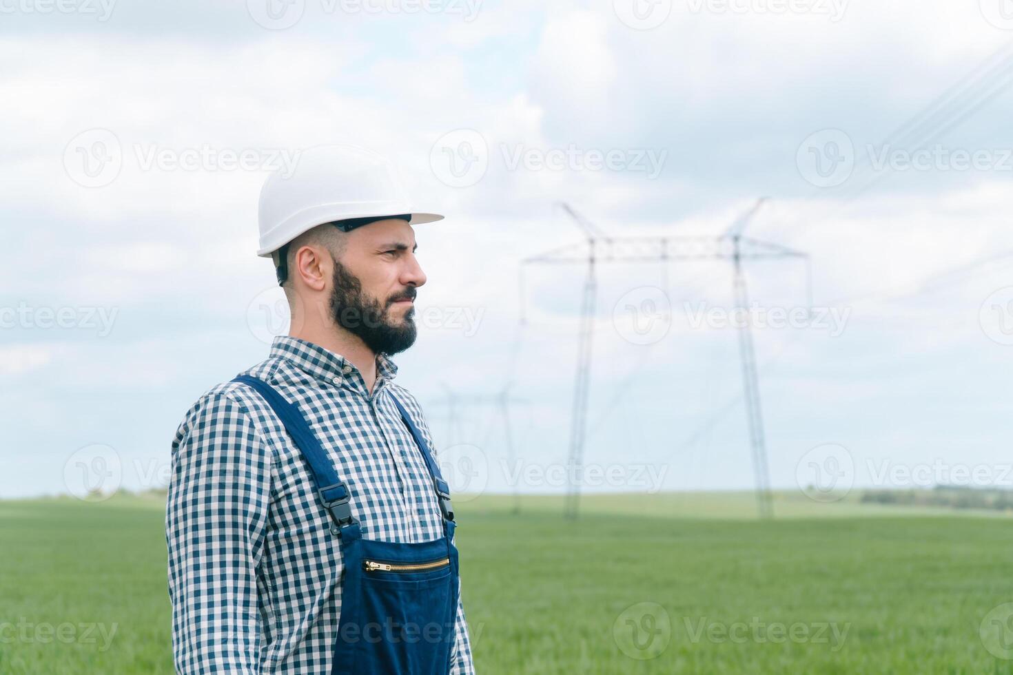 Portrait of engineer near transmission lines. Energy efficiency conception. Transmission towers photo