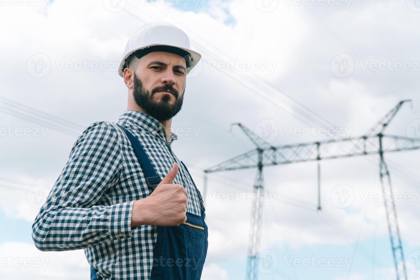 Portrait of engineer near transmission lines. Energy efficiency conception. Transmission towers photo