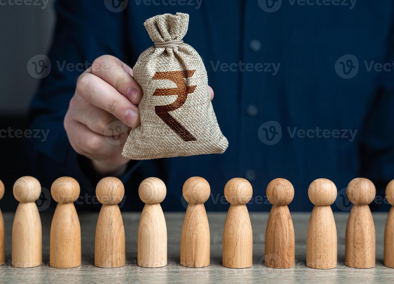 A man holds a indian rupee money bag above the crowd.Salaries. Crowdfunding and fundraising. Social politics. Deposits and loans. Budgetary funds for social policy. photo