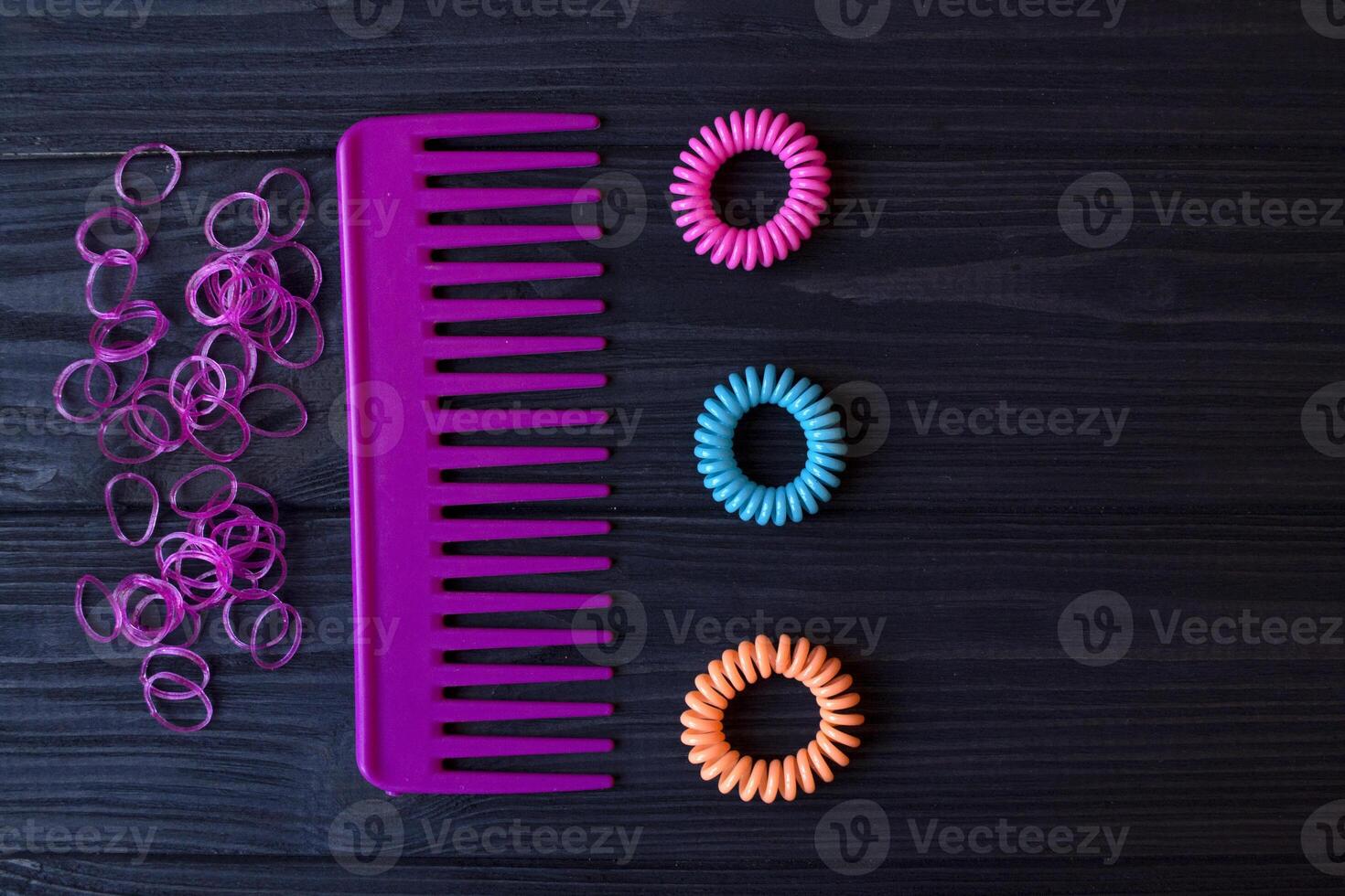 Colorful and bright cosmetics. Beauty care tools. Beauty salon. Girl's paradise. Nail polishes, sequins, pink hair bands and comb on a dark blue wooden desk. Bright still life of beauty instruments. photo