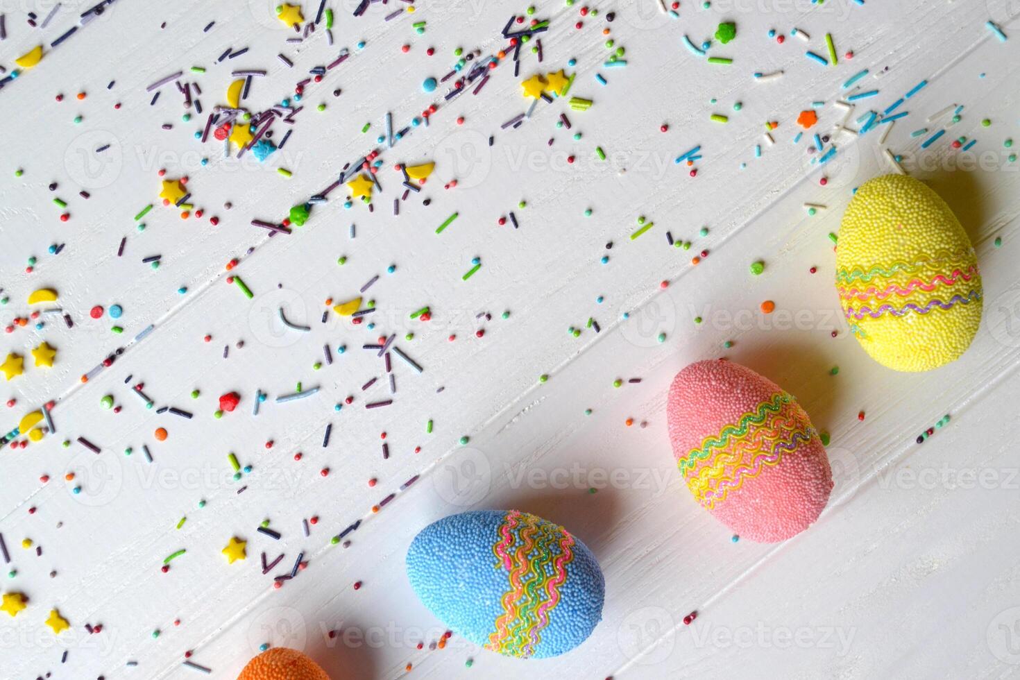 Colorful easter eggs bright sweet powder for easter cake on the white wooden table. Beautiful easter background. Easter card. Homemade holiday decor. photo