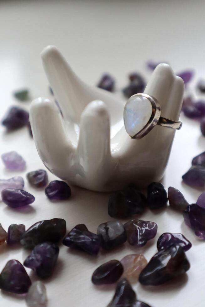 Silver ring with moonstone on porcelain hand and amethyst kiesel. photo
