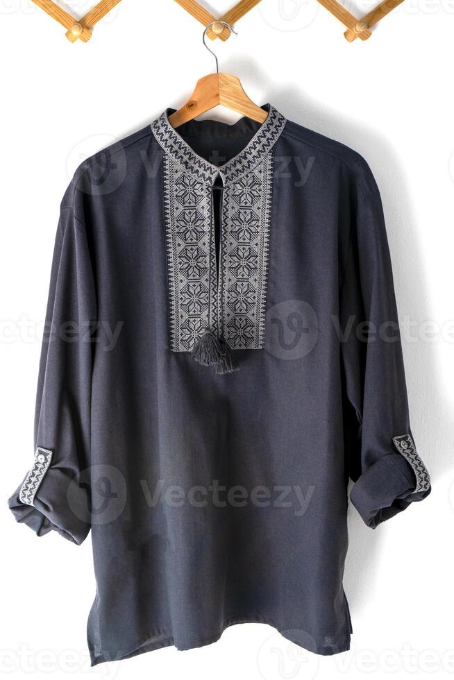 Ukrainian clothes embroidered man shirt. Blue gray and black threads background. Vyshyvanka is a symbol of Ukraine. Embroidery cross stitching. National Ukrainian stitch. Traditional clothing symbol photo