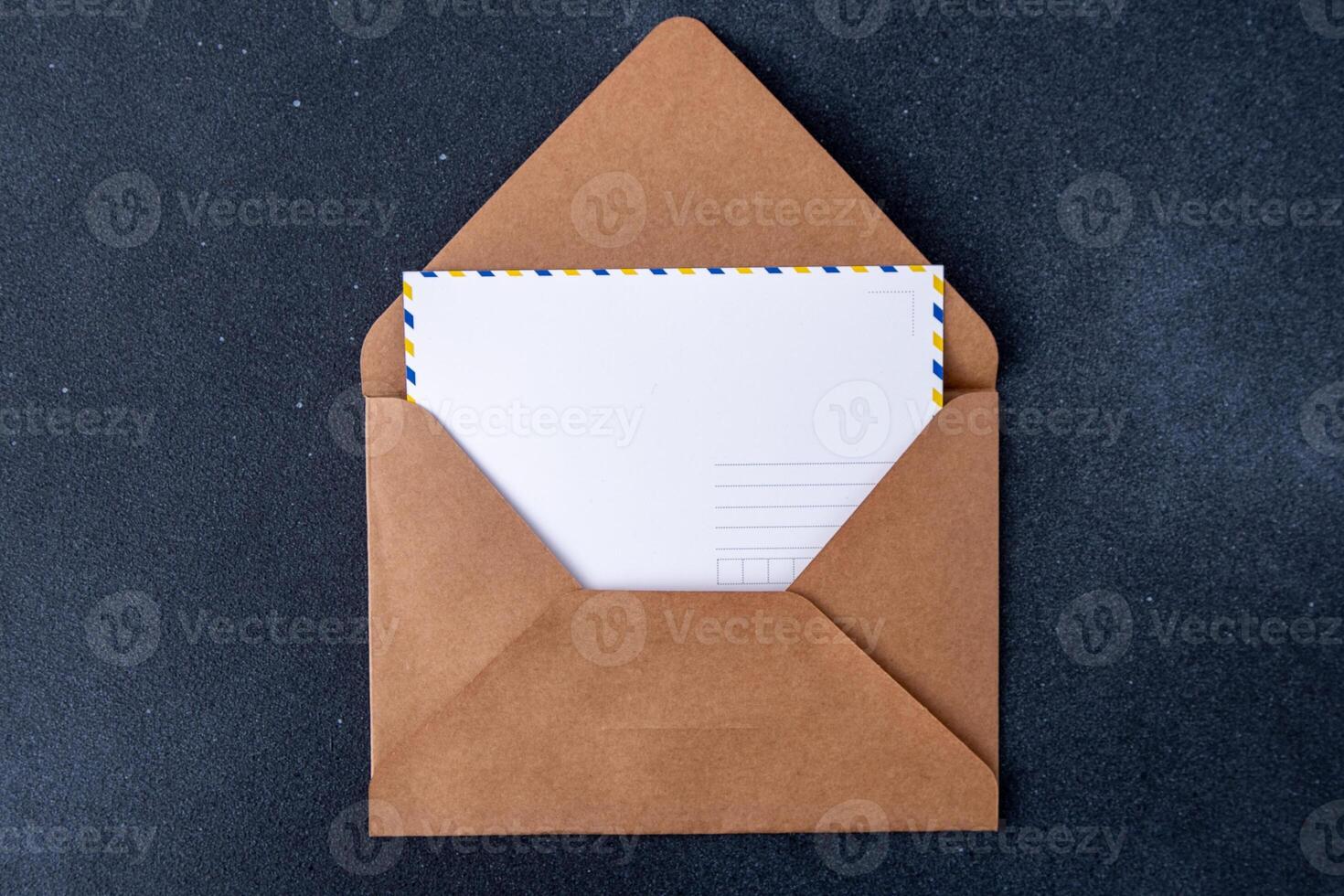 Open craft brown envelope and postcard form. Letter with copy space. Mail card photo