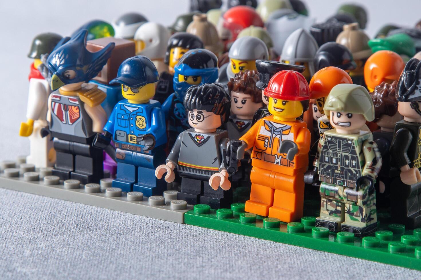 Lego mini figures set of different. Game toy man. Children's game constructor bricks. Crowd of friends. Ukraine, Kyiv - January 17, 2024. photo