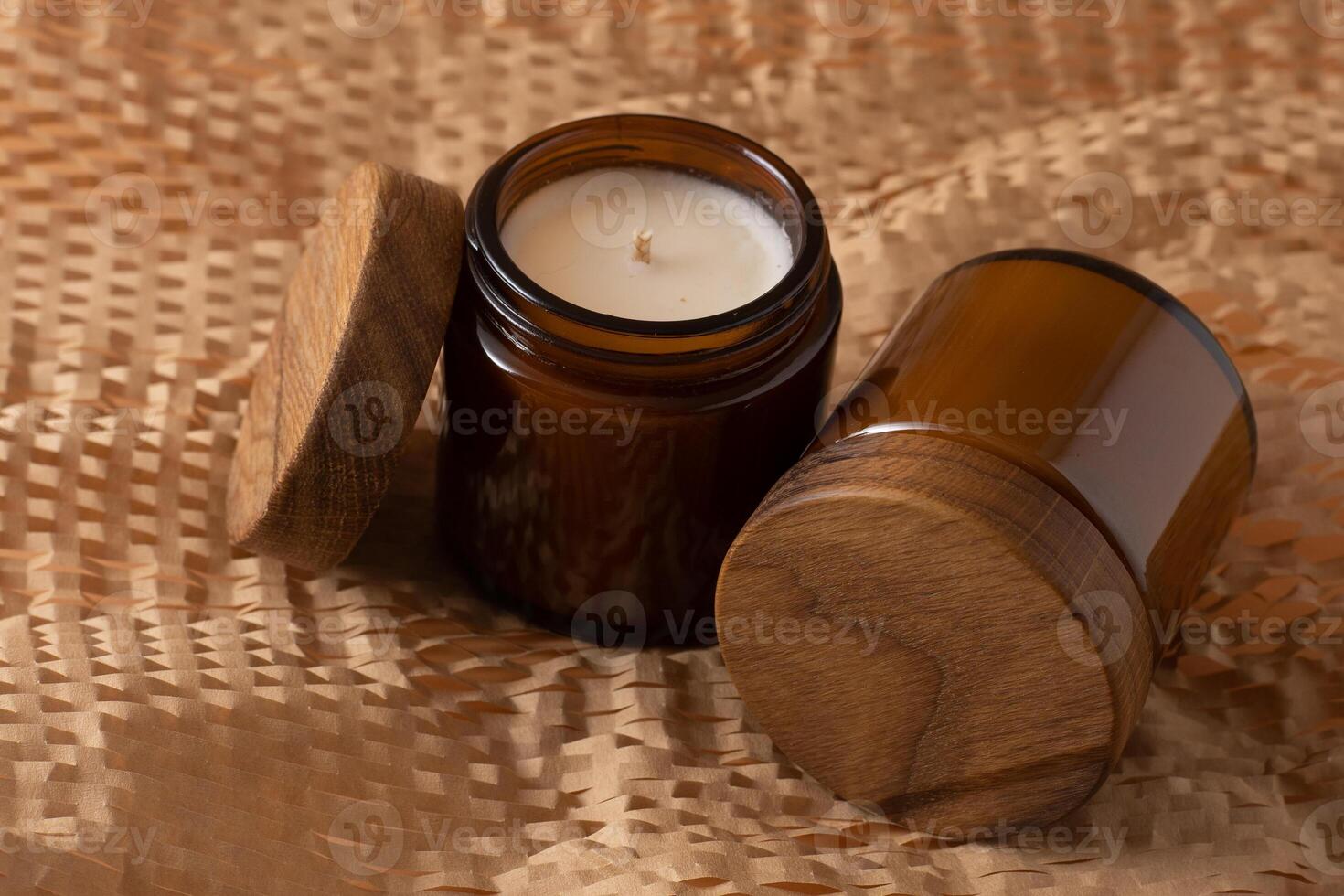 Soy candles in a brown glass jar with a wooden lid. Aromatherapy. Candle on a beige background. Place for a label. Wax and wick. Home decor. Handmade. air freshener. photo
