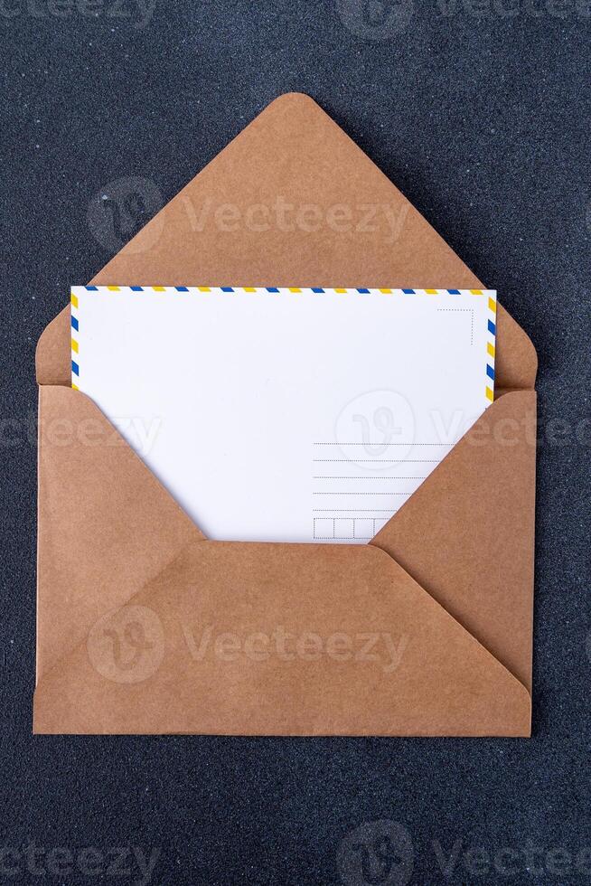 Open craft brown envelope and postcard form. Letter with copy space. Mail card photo