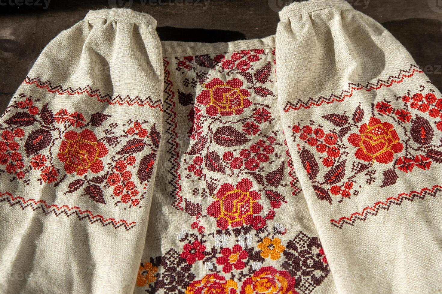 Ukrainian clothes embroidered shirt. Red orange and black threads background. Vyshyvanka is a symbol of Ukraine. Embroidery cross stitching. National Ukrainian stitch. Traditional clothing symbol photo