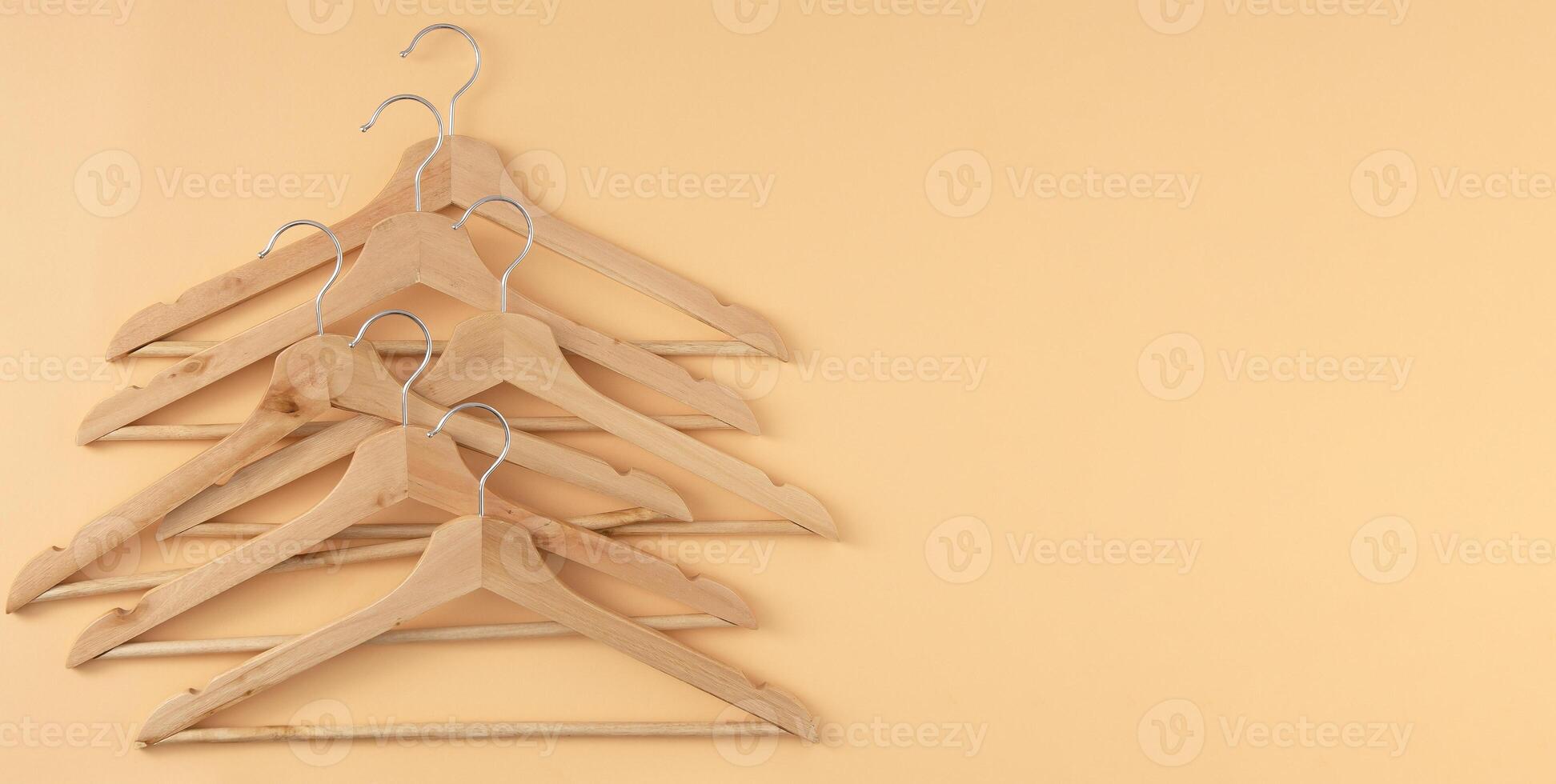 Hangers for clothes. Hanger set. Beige background copy space banner. Wooden hangers. Store shop photo