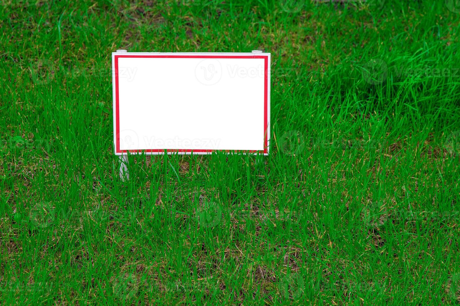 Pointer sign on the lawn with green grass. Banner layout with place for the text dog walking is prohibited, do not walk on the lawn, it is dangerous. Information board layout. Mockup. photo