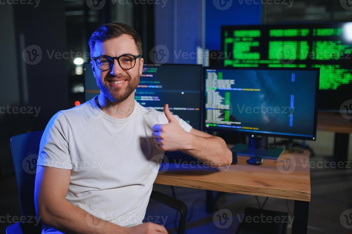 Male programmer working on desktop computer at white desk in office photo