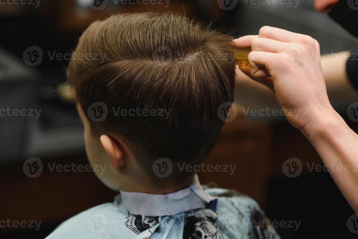 alegre caucásico chico consiguiendo peinado en barbería foto