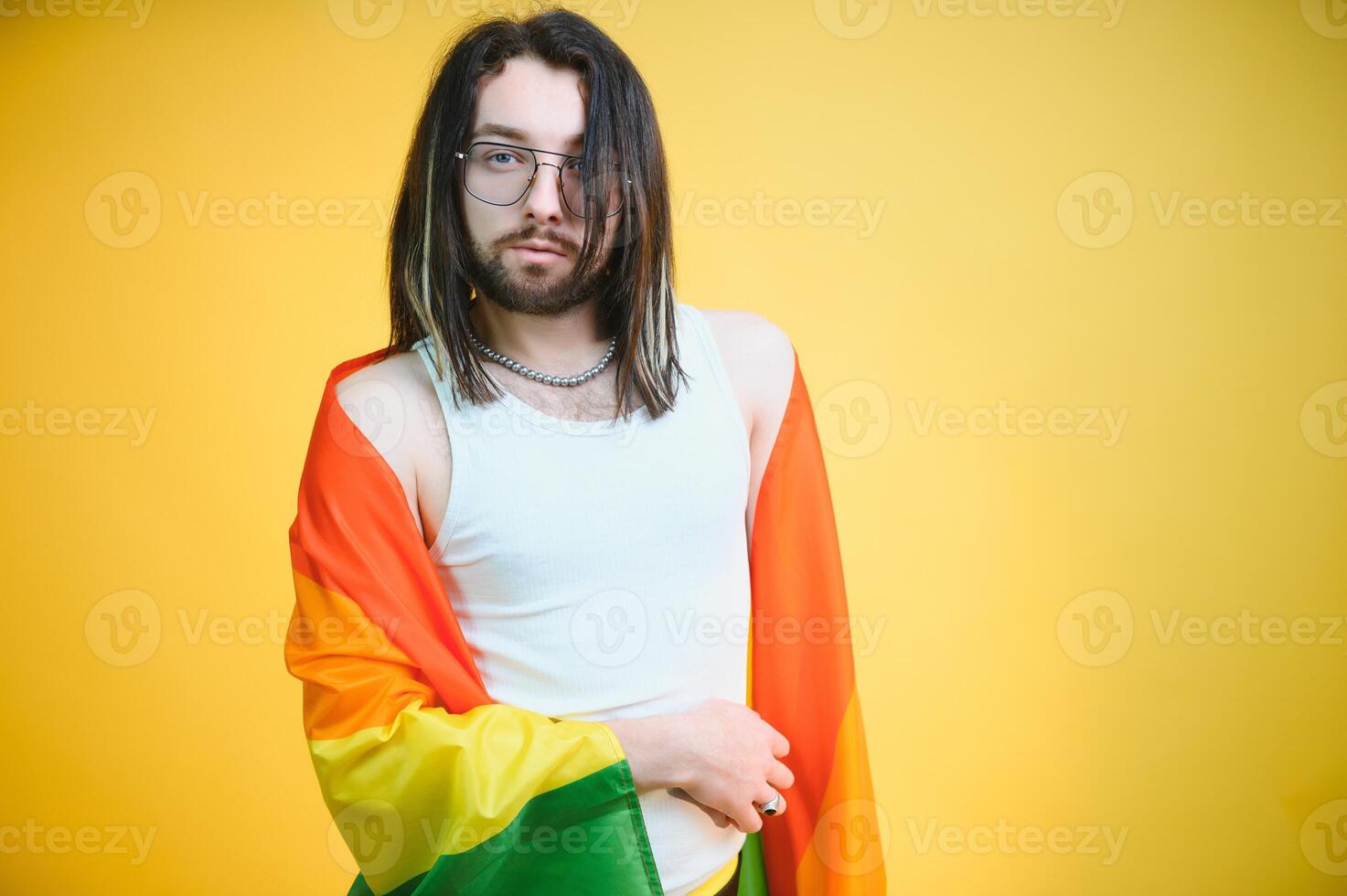 Young gay man is standing in the studio and posing for a camera. photo