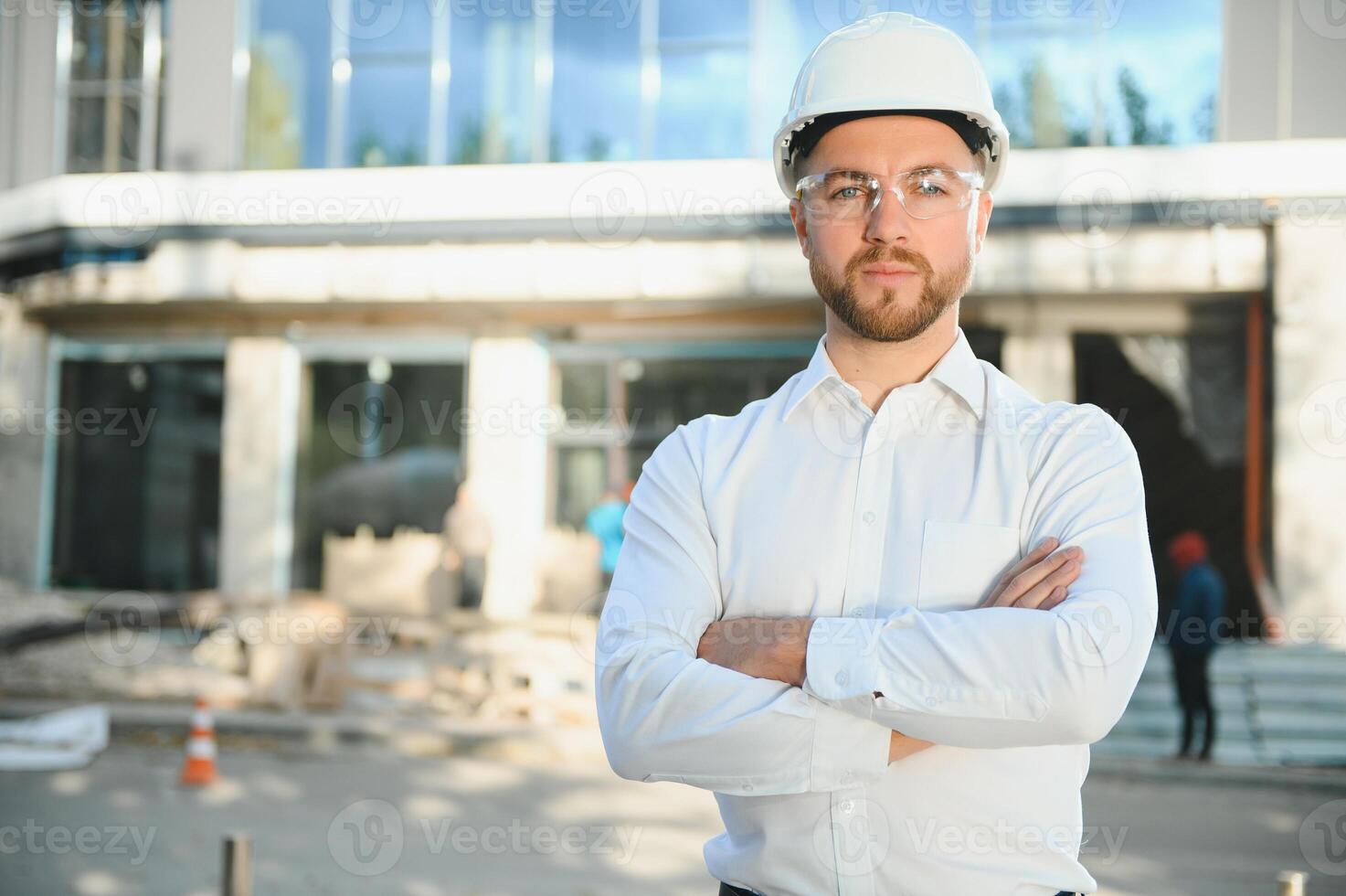 Engineer next to building cranes. Concept - large construction project. Architect directs the construction process. Drawings and tablet in the hands. photo