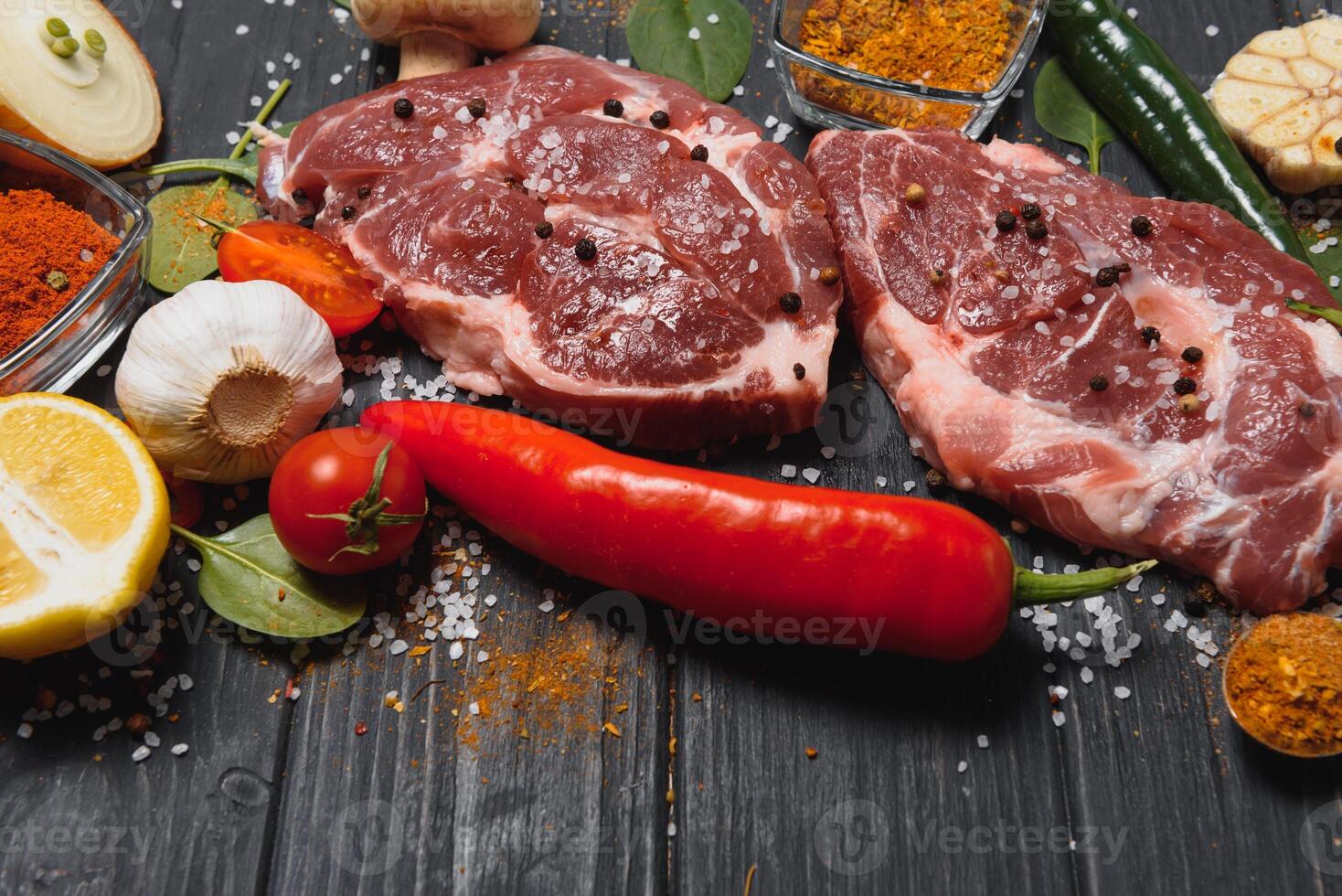 Raw pork chop steak prepare in kitchen with vegetable and spices for food and cooking concept photo