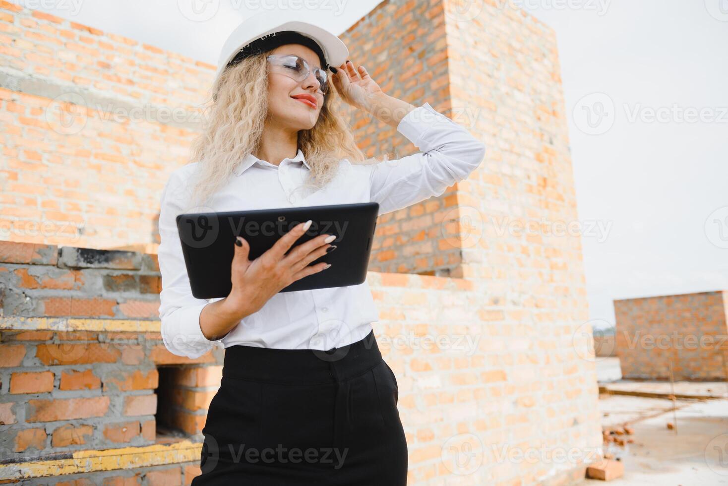 construcción ingeniero. niña con construcción documentación. un mujer en un blanco difícil sombrero en contra el techo de un edificio. construcción de un nuevo casa foto