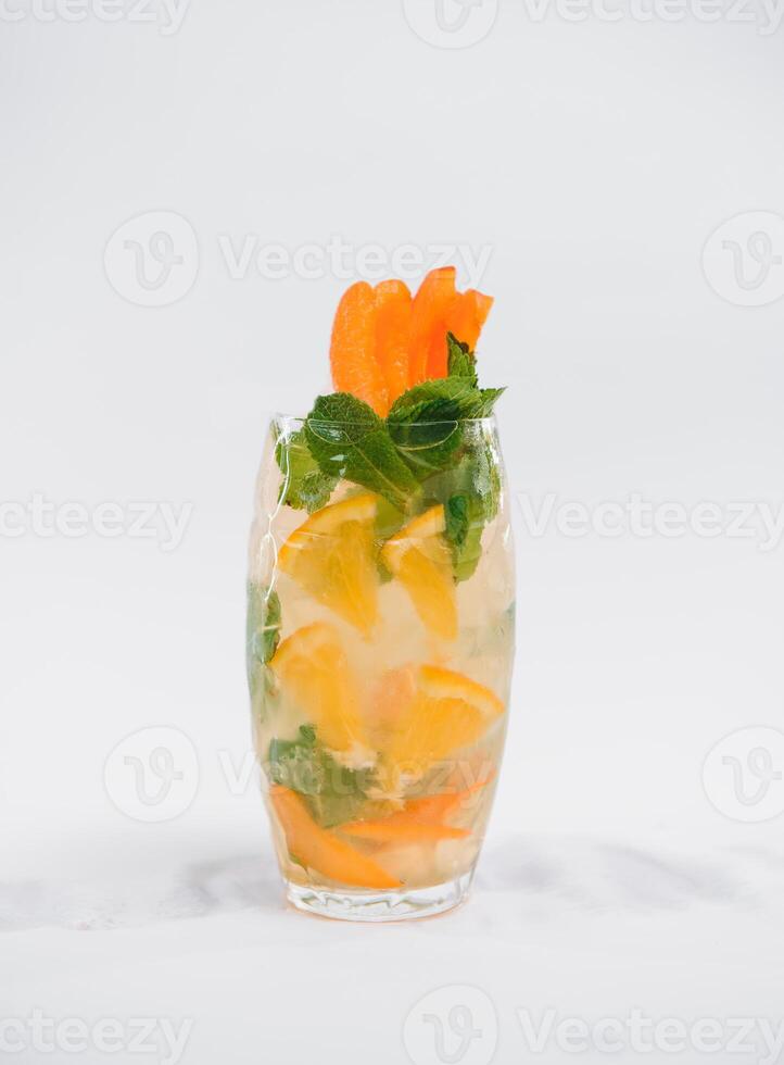 Glasse Of Drink With Ice Cubes And Fruits On White Background photo