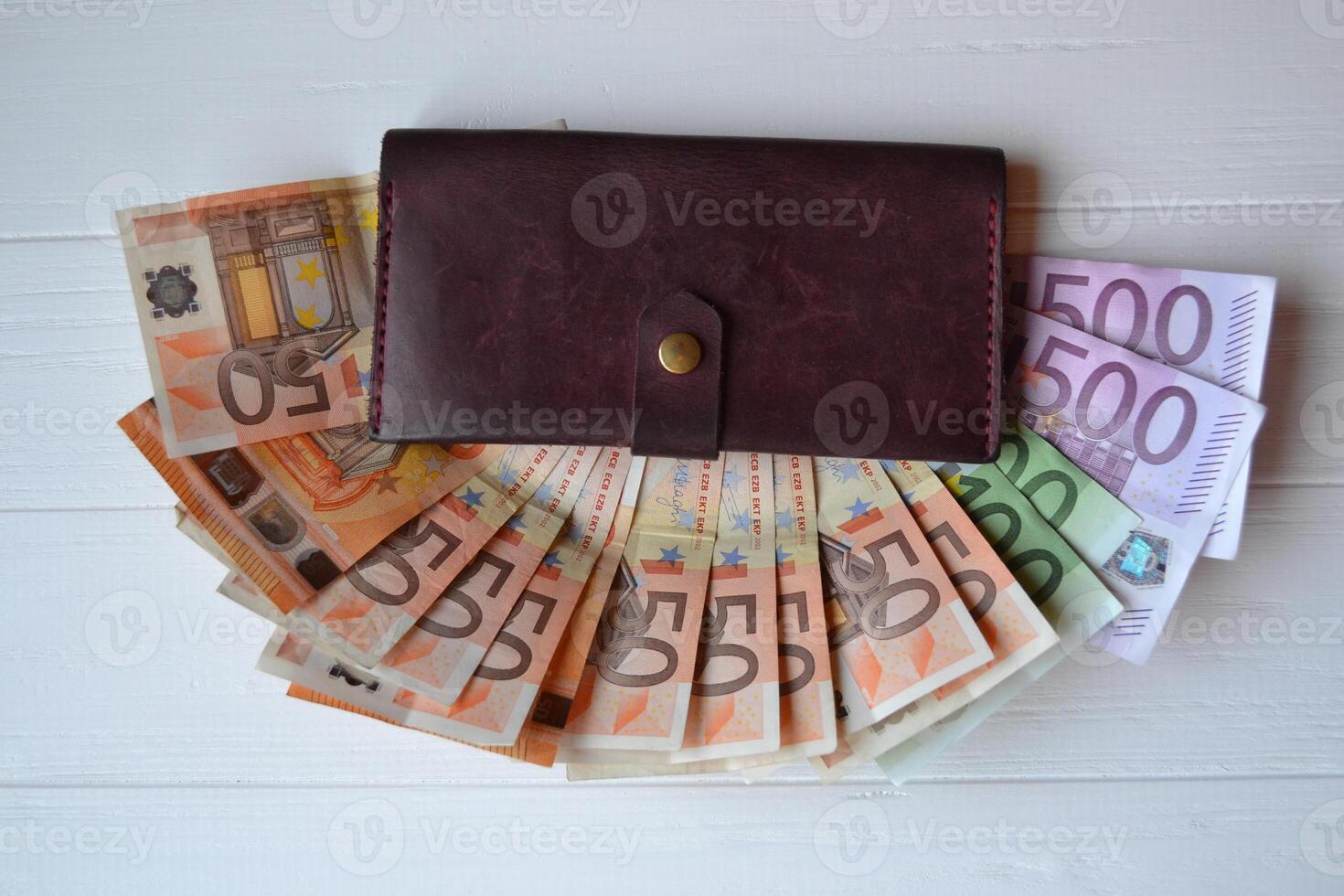 Euro money banknotes and wallet on the white wooden desk. Business money background. photo