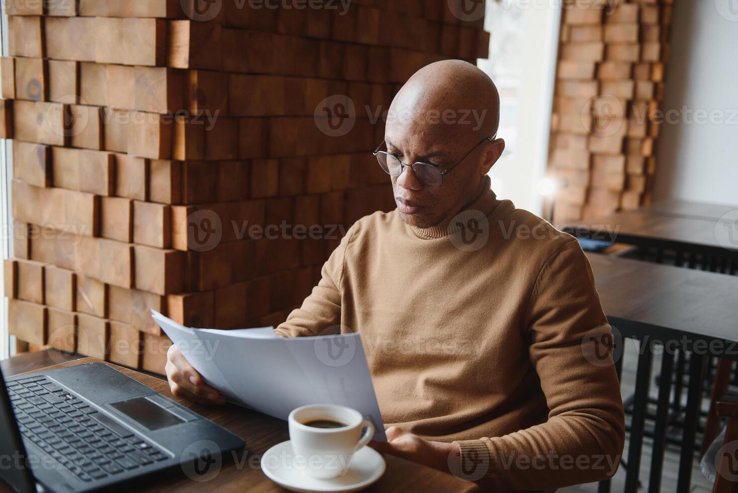 Planning The Day. Calm black student writing his lesson schedule in notebook, sitting in modern bar, empty space. photo