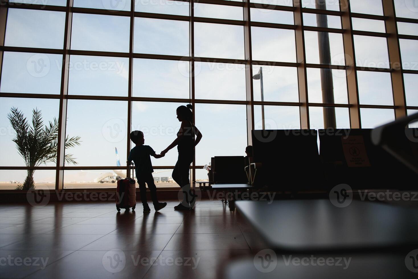 Mom with a little son and a suitcase at the airport. Travel concept photo