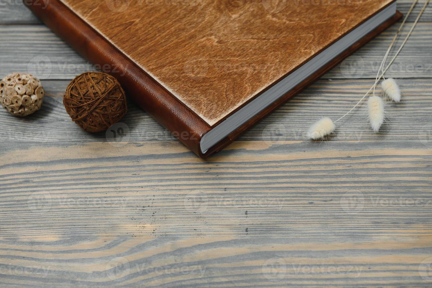 Family photo book with embossing. Photo book on a wooden background. Brown photo book with wood cover. Photoalbum with a hard cover. Wedding photo album.