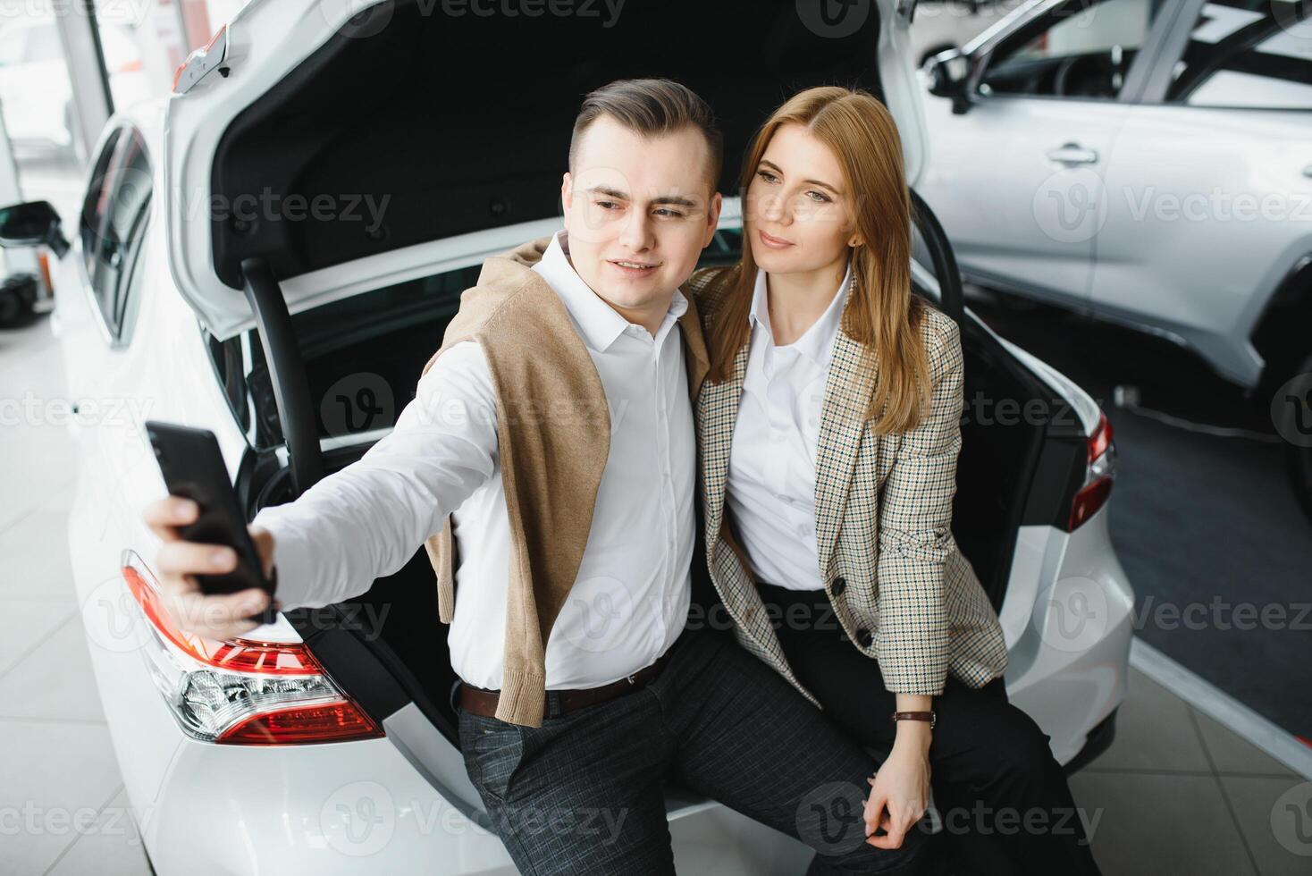 joven hermosa contento Pareja comprando un coche. marido comprando coche para su esposa en un salón. coche compras concepto foto