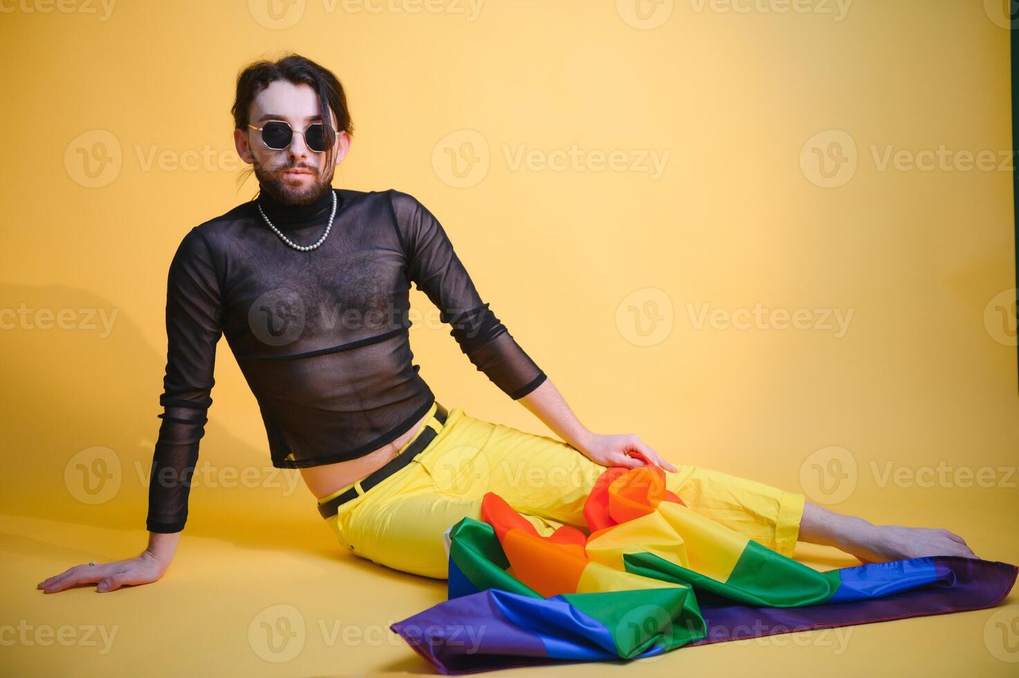 joven gay hombre es en pie en el estudio y posando para un cámara. foto