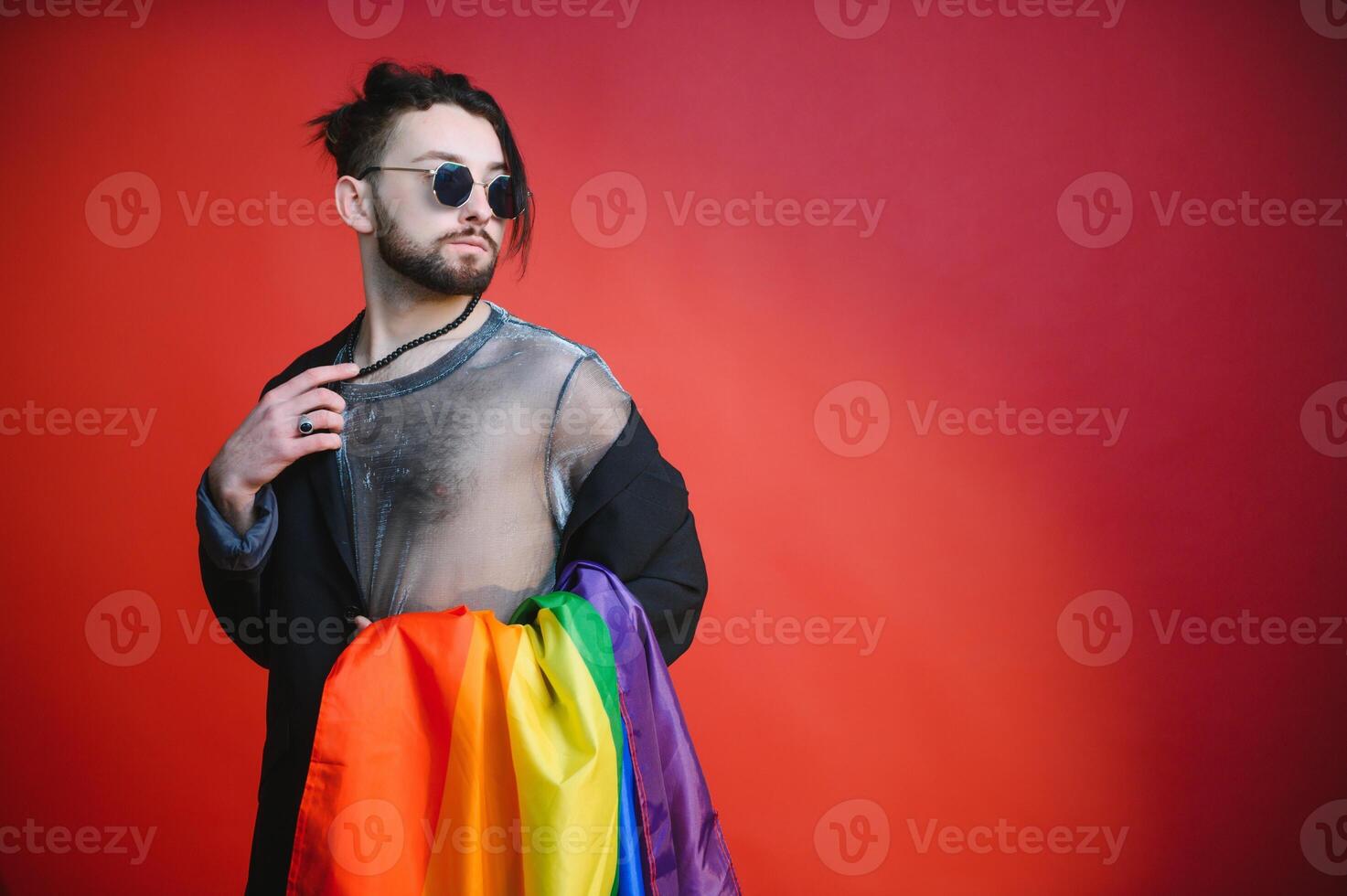 Happy gay man having fun holding rainbow flag symbol of LGBTQ community photo