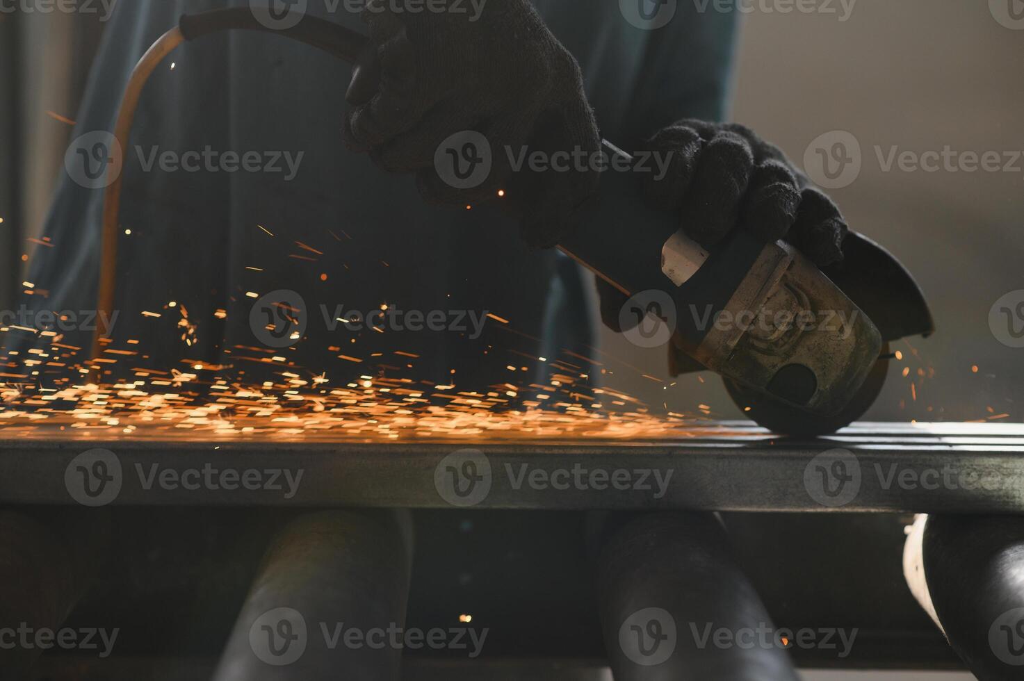 Close-up of worker cutting metal with grinder. Sparks while grinding iron. Low depth of focus photo