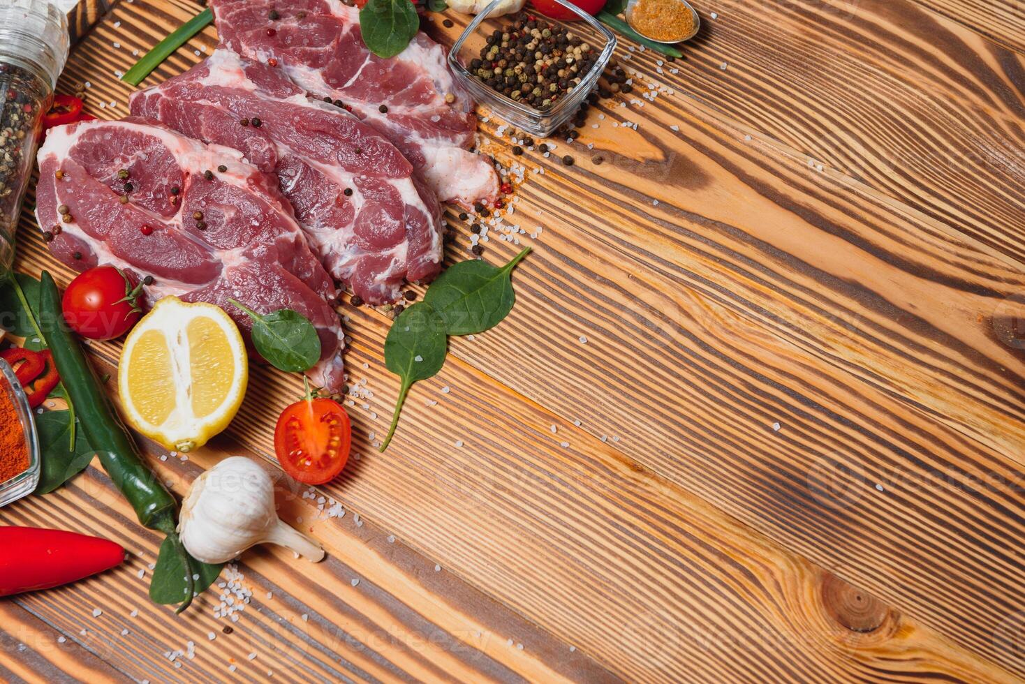 Raw pork chop steak prepare in kitchen with vegetable and spices for food and cooking concept photo