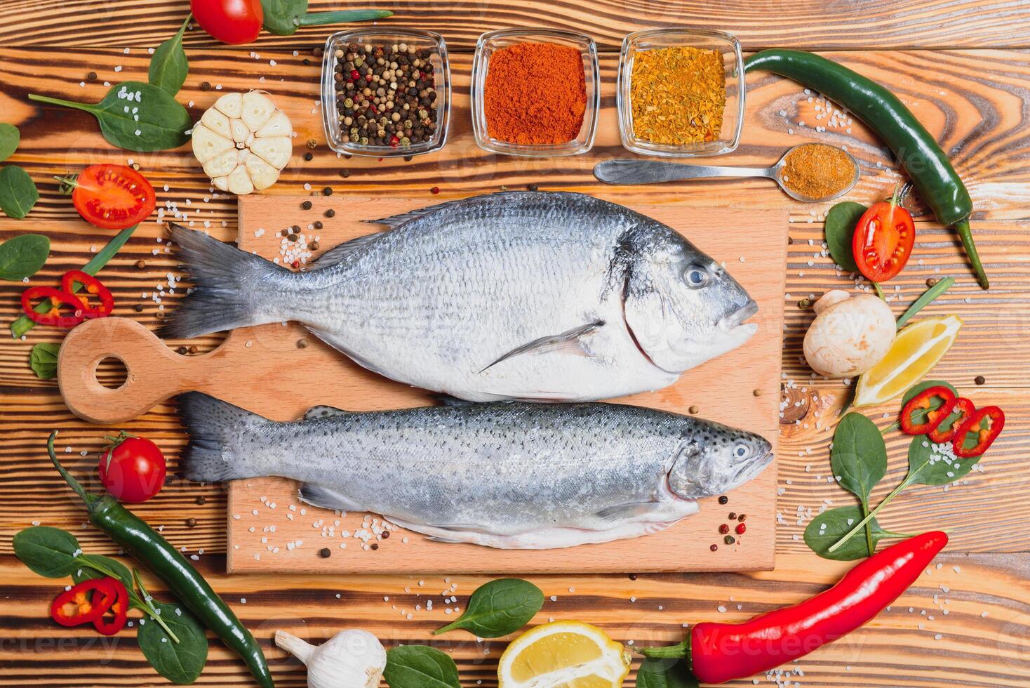 crudo pescado Cocinando y ingredientes. dorado, limón, hierbas y especias parte superior ver con Copiar espacio en mesa foto