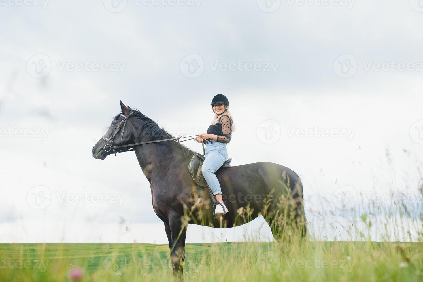 hermosa niña montando un caballo en campo. foto