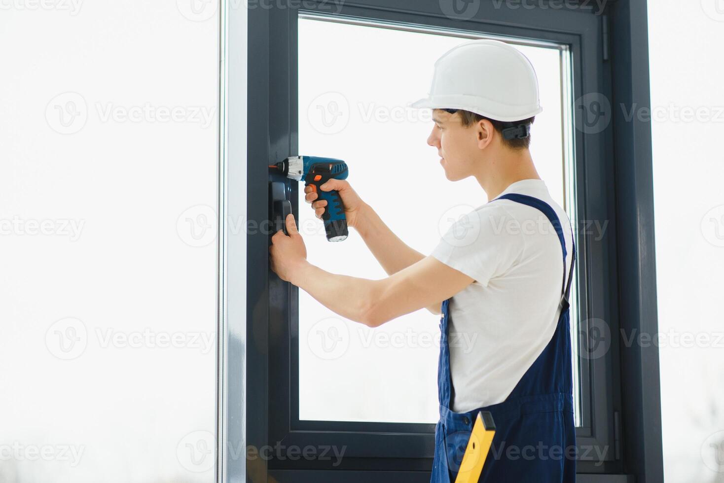 Construction worker installing window in house photo