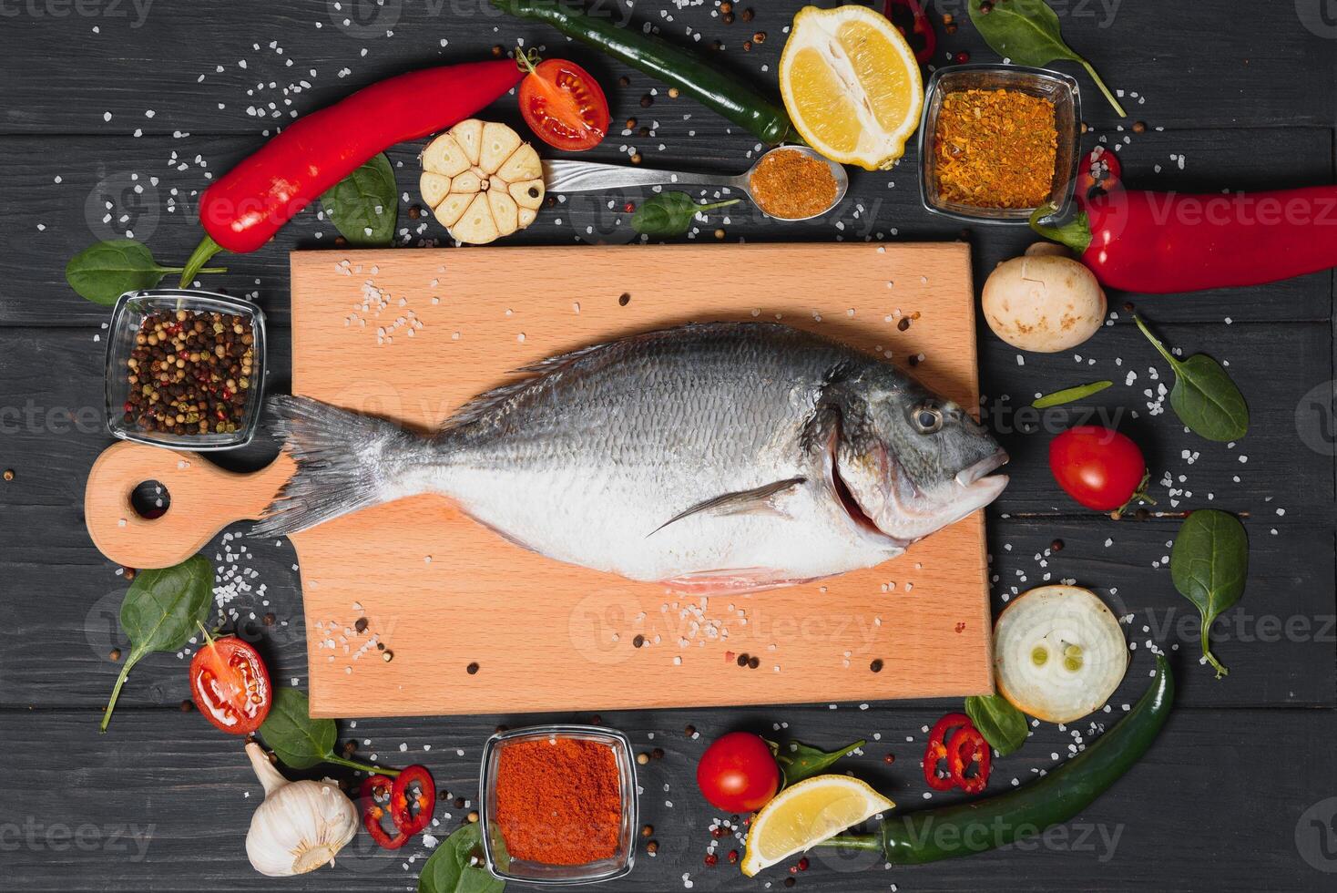 crudo pescado Cocinando y ingredientes. dorado, limón, hierbas y especias parte superior ver con Copiar espacio en mesa foto