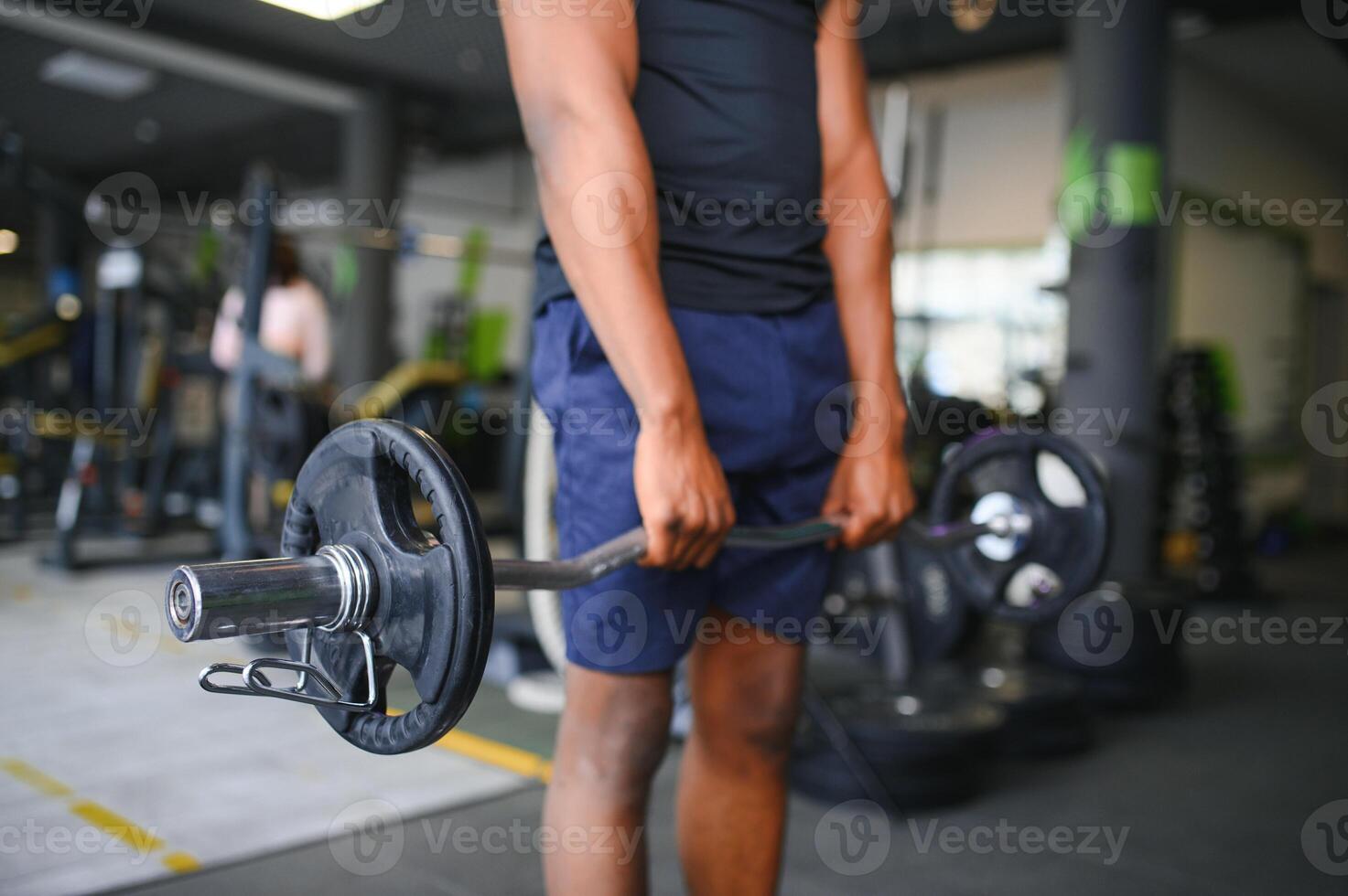 Portrait Of Athletic Man With Barbell In Hands Exercising At Gym photo
