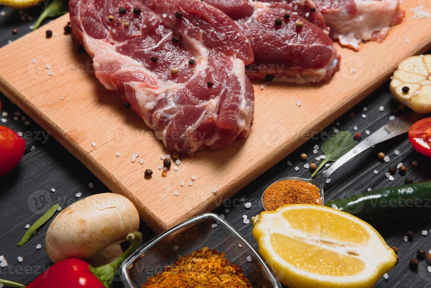raw meat with fresh vegetables and spices on wooden background. Top view. Free space for text. prepare yourself concept. photo